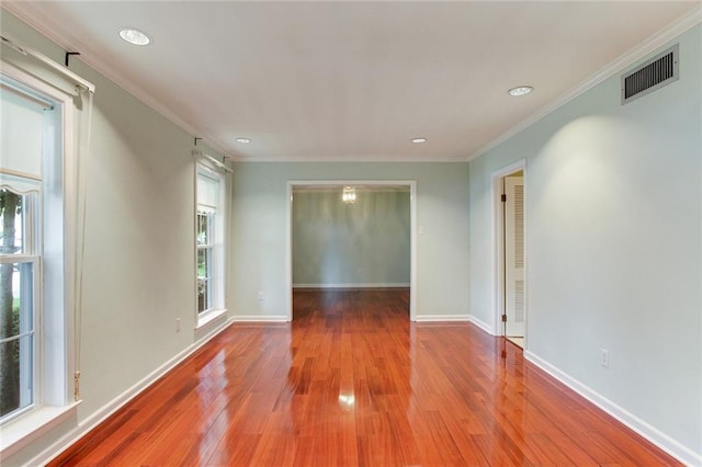 unfurnished room featuring crown molding, hardwood / wood-style floors, and a wealth of natural light