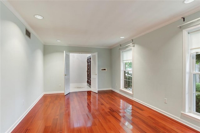 spare room featuring ornamental molding and hardwood / wood-style flooring