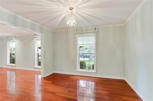 unfurnished room featuring hardwood / wood-style flooring, ornamental molding, and a wealth of natural light