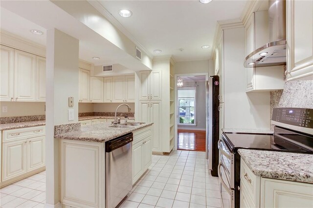 kitchen with light tile patterned floors, sink, wall chimney range hood, and stainless steel appliances