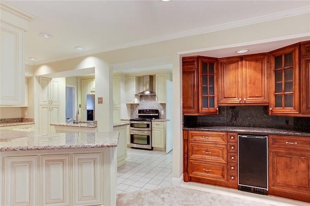 kitchen featuring decorative backsplash, light stone counters, wall chimney exhaust hood, light tile patterned floors, and double oven range