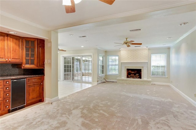 interior space featuring ceiling fan, light colored carpet, and a fireplace