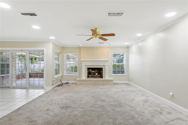 unfurnished living room featuring ceiling fan, a fireplace, light carpet, and crown molding