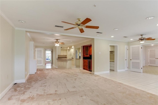 unfurnished living room featuring ceiling fan, wine cooler, light carpet, and ornamental molding