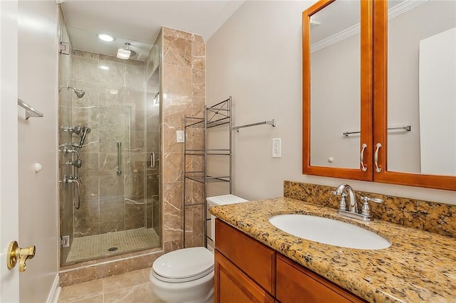 bathroom featuring vanity, crown molding, toilet, and a shower with door