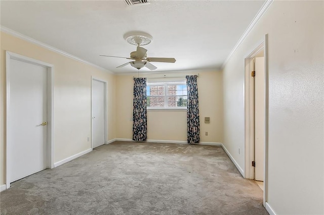 empty room with ceiling fan, crown molding, and light carpet