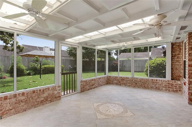 unfurnished sunroom featuring ceiling fan and a healthy amount of sunlight