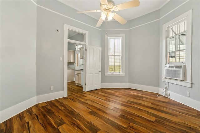 spare room featuring ceiling fan, dark wood-type flooring, baseboards, and ornamental molding