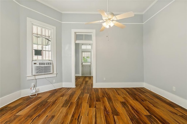 empty room with dark wood finished floors, baseboards, and ornamental molding