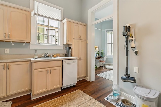 kitchen featuring dark wood finished floors, light brown cabinetry, a sink, light countertops, and dishwasher