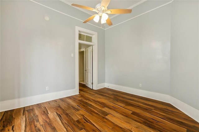 empty room featuring ornamental molding, baseboards, dark wood-style flooring, and ceiling fan