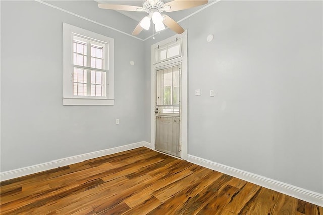 unfurnished room featuring a ceiling fan, baseboards, and wood finished floors