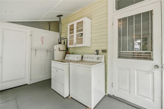 clothes washing area featuring water heater, laundry area, and separate washer and dryer