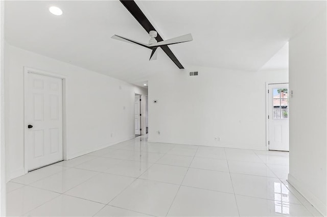 tiled spare room featuring lofted ceiling with beams and ceiling fan