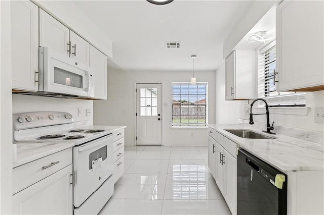 kitchen featuring light stone countertops, white appliances, sink, white cabinetry, and hanging light fixtures