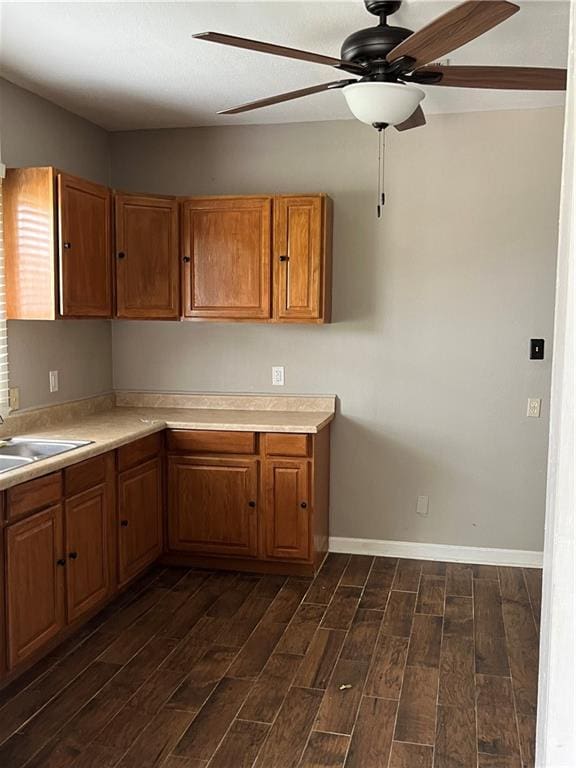 kitchen with ceiling fan, sink, and dark wood-type flooring