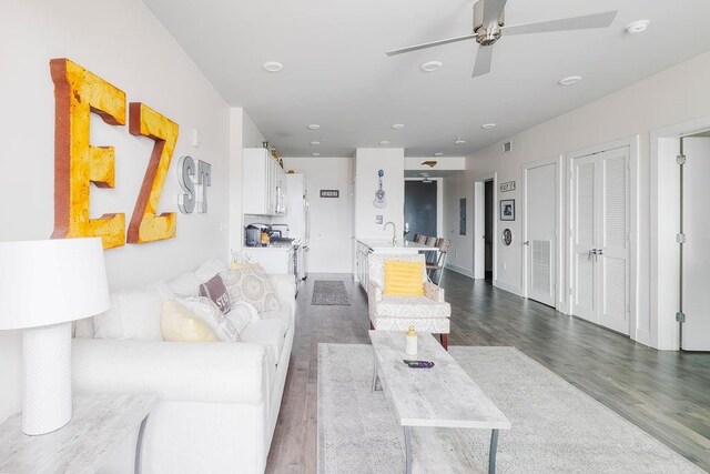 living room featuring ceiling fan, sink, and hardwood / wood-style flooring