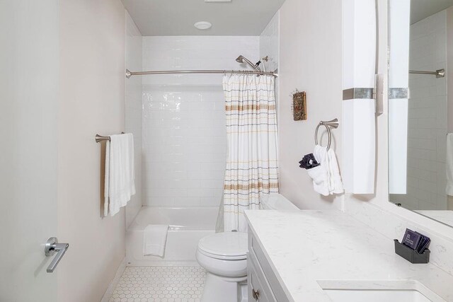 full bathroom featuring vanity, tiled shower / bath, tile patterned flooring, and toilet