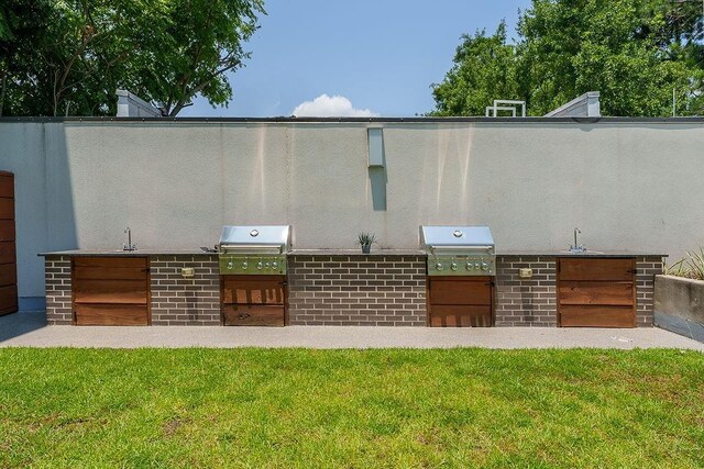 view of patio with exterior kitchen, sink, and grilling area