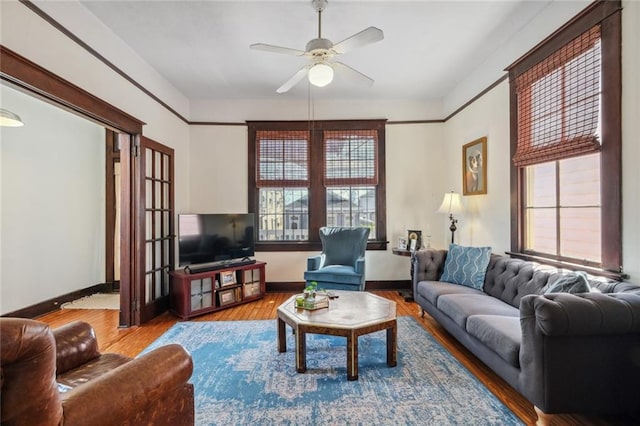 living room featuring wood-type flooring, ceiling fan, and plenty of natural light