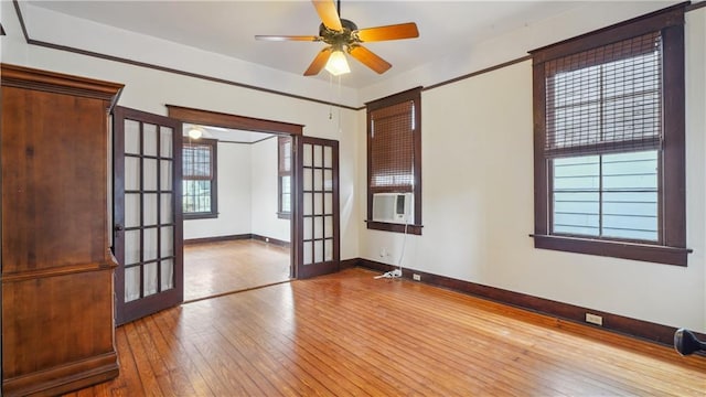 spare room featuring cooling unit, wood-type flooring, french doors, and ceiling fan