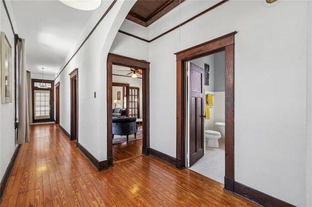 hallway with crown molding and wood-type flooring