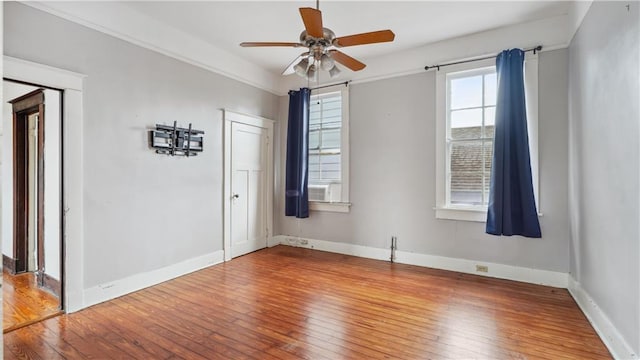 unfurnished room with cooling unit, ceiling fan, and wood-type flooring