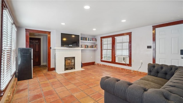 tiled living room with cooling unit and a brick fireplace