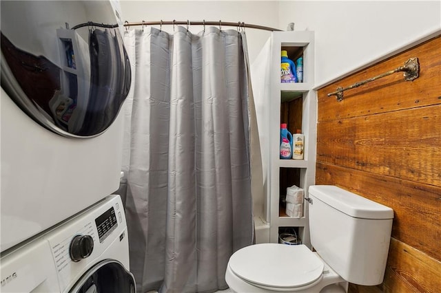 bathroom with toilet and stacked washing maching and dryer