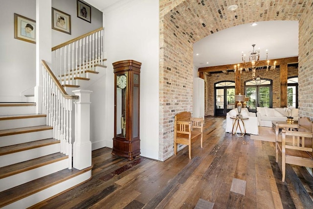 interior space featuring brick ceiling, french doors, wood-type flooring, and an inviting chandelier