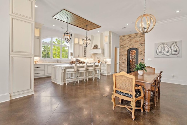 dining space with crown molding and sink