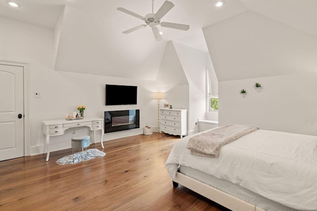 bedroom with ceiling fan, vaulted ceiling, and hardwood / wood-style flooring