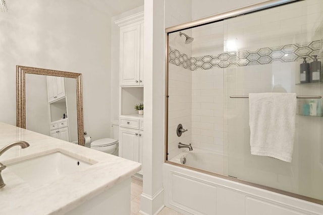 full bathroom featuring shower / bath combination with glass door, vanity, and toilet