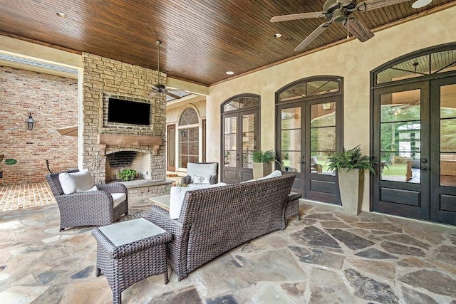 view of patio featuring french doors, an outdoor brick fireplace, and ceiling fan