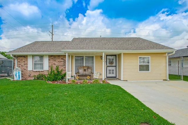 ranch-style house featuring brick siding, fence, a front yard, and roof with shingles