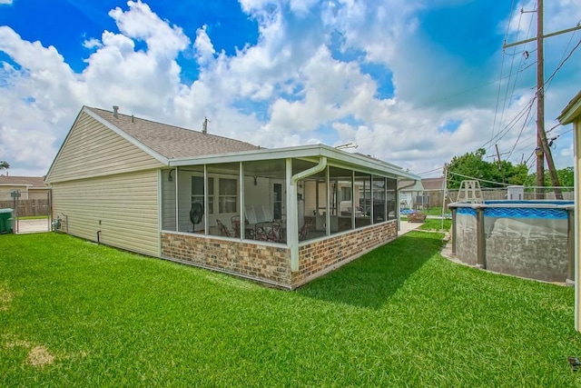 rear view of house featuring a lawn, fence, a fenced in pool, and a sunroom