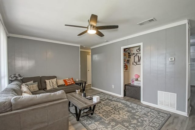 living room featuring visible vents, wood finished floors, and ornamental molding