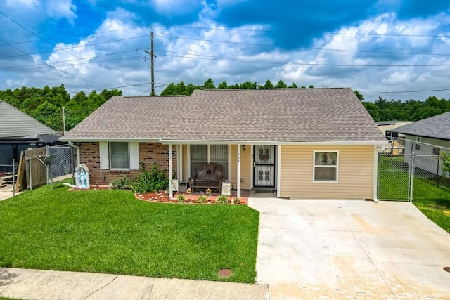 ranch-style house with a gate, a porch, roof with shingles, a front yard, and brick siding