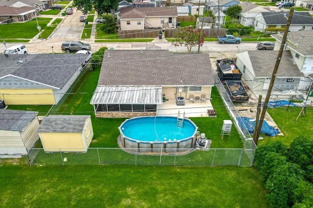 view of swimming pool featuring a fenced in pool, a fenced backyard, a residential view, and a lawn