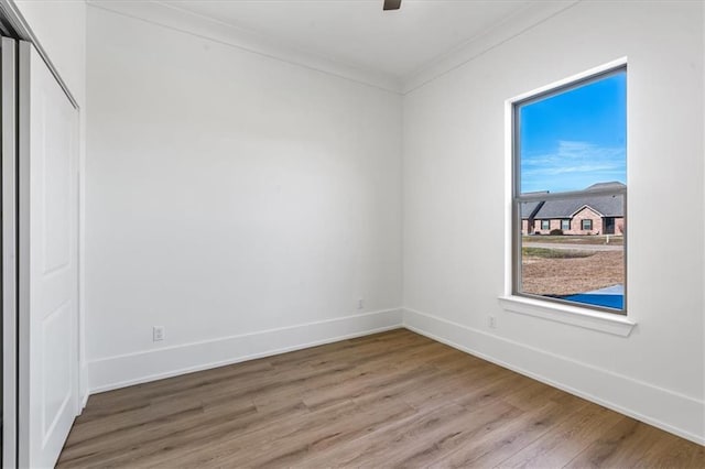 unfurnished room featuring hardwood / wood-style flooring and crown molding