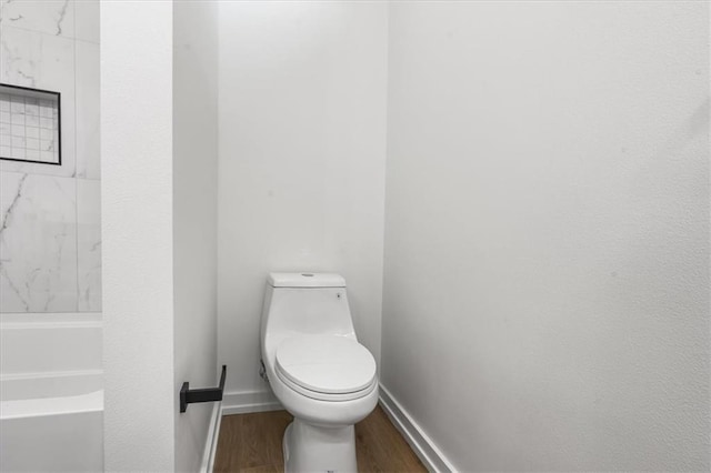 bathroom featuring wood-type flooring and toilet