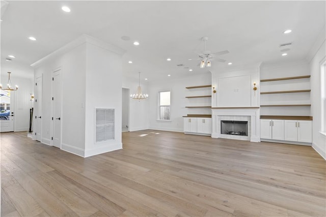 unfurnished living room featuring light wood-type flooring and ceiling fan with notable chandelier