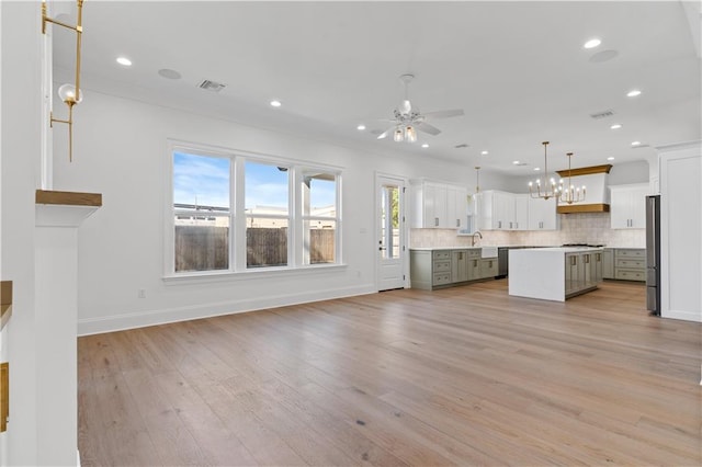 unfurnished living room featuring ceiling fan, a healthy amount of sunlight, and light hardwood / wood-style flooring