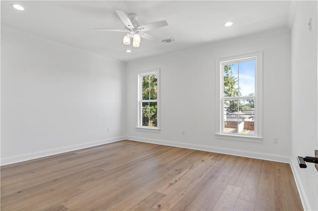 empty room with a wealth of natural light, ornamental molding, ceiling fan, and light wood-type flooring