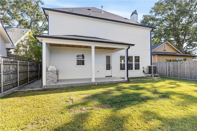 rear view of house featuring a patio, central AC unit, and a yard