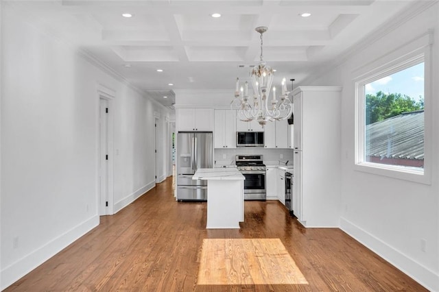 kitchen featuring a kitchen island, appliances with stainless steel finishes, hardwood / wood-style floors, decorative light fixtures, and coffered ceiling