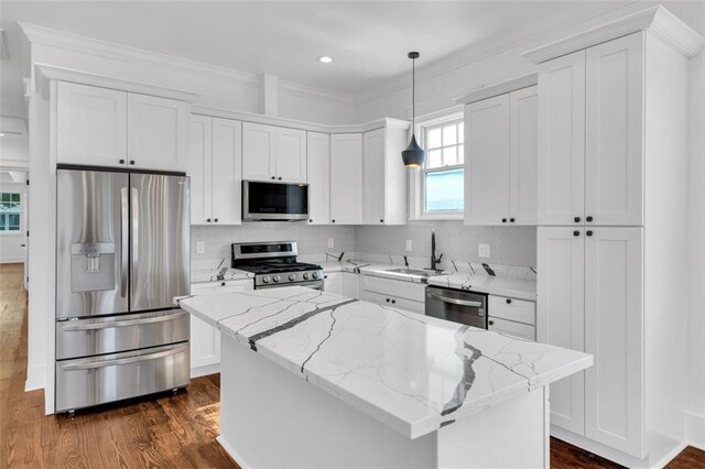 kitchen featuring appliances with stainless steel finishes, hanging light fixtures, dark hardwood / wood-style floors, and a kitchen island