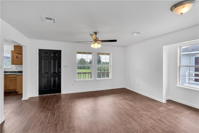 unfurnished living room with dark hardwood / wood-style floors and ceiling fan