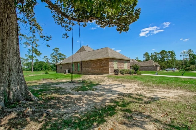 view of side of home with a yard and brick siding