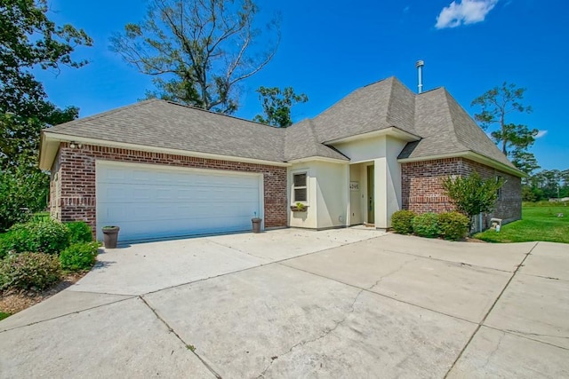 view of front facade with an attached garage, a shingled roof, concrete driveway, and brick siding